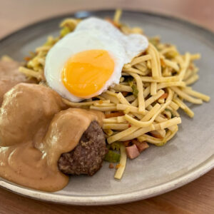 Bami met gehaktballetjes in pindasaus en gebakken ei.