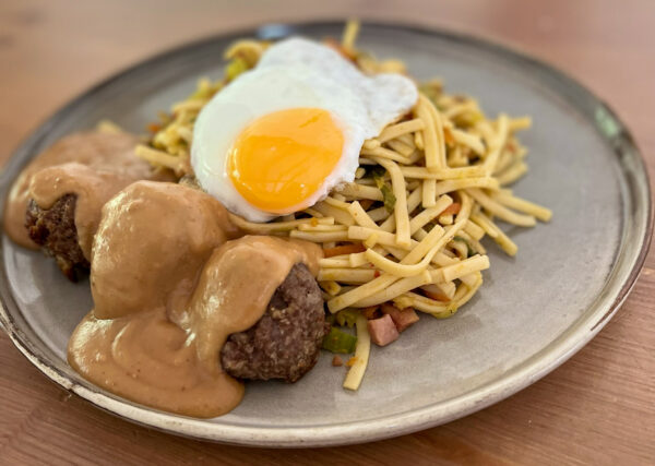 Bami met gehaktballetjes in pindasaus en gebakken ei.