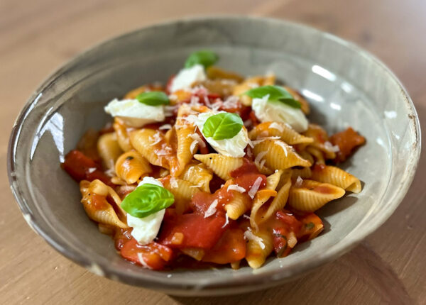 Pasta met geroosterde paprika roomkaas en basilicum.
