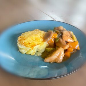 Stoofpot van kippendijen en seizoensgroenten met aardappelgratin.